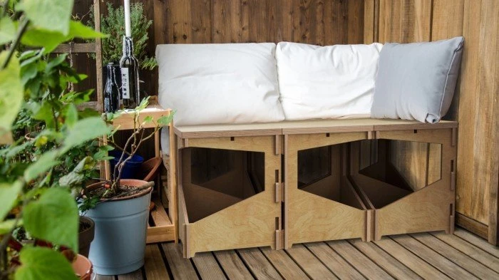 Dřevěná lavice s úložným prostorem na panelákovém balkóně.