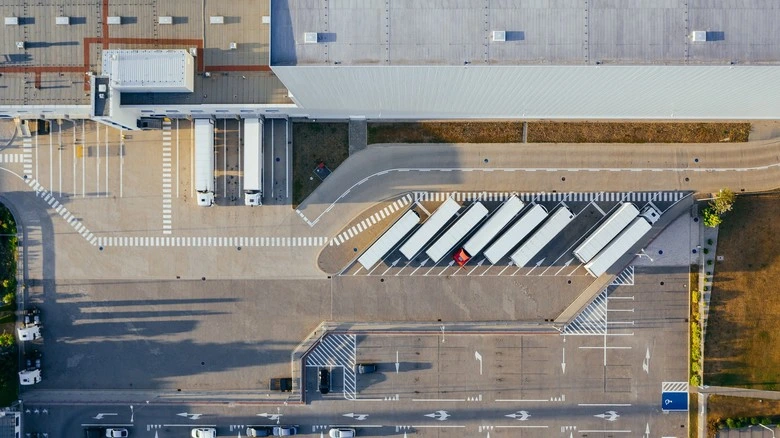Vzdušný pohled na logistické centrum s nákladními auty.