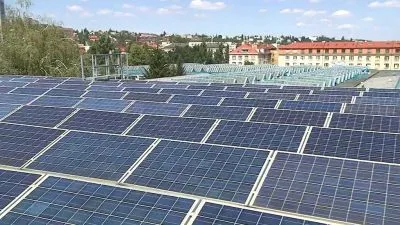 Fotovoltaické panely na střeše budovy v řadách.