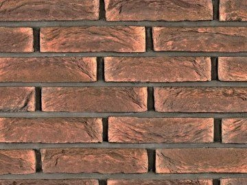 Detail cihlového obkladu na stěně s viditelnými švy.
