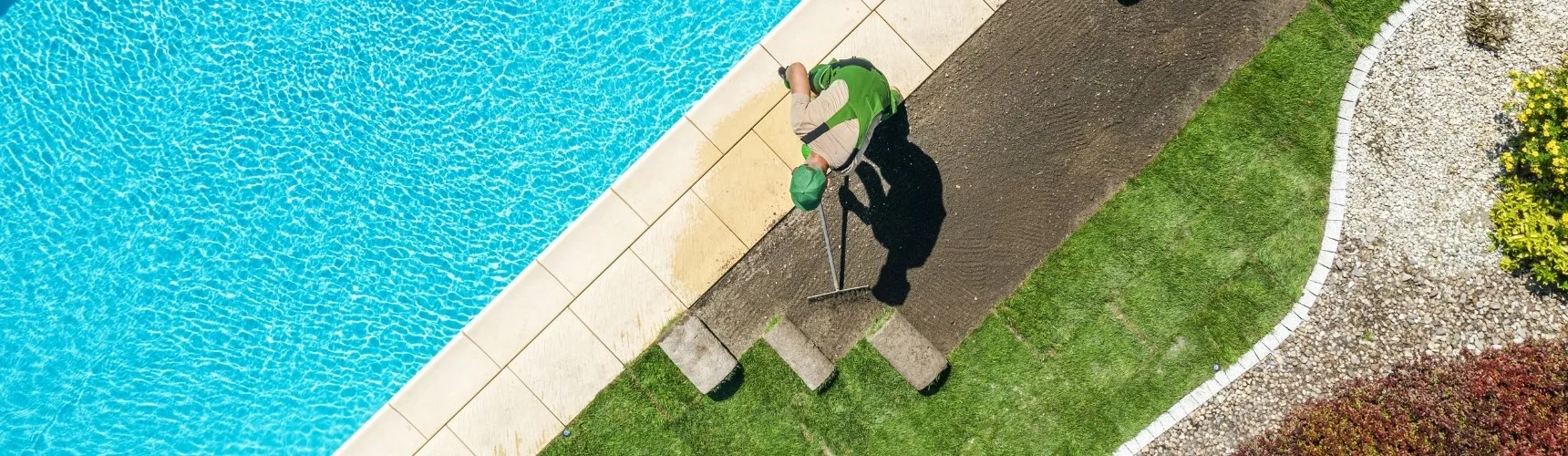 Muž čistí betonovou plochu kolem nadzemního bazénu.