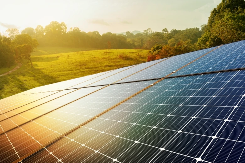 Fotovoltaické panely na trávnaté svah v přírodě za slunečního světla.