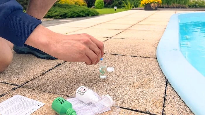 Testování vody v bazénu pomocí chemických prostředků.