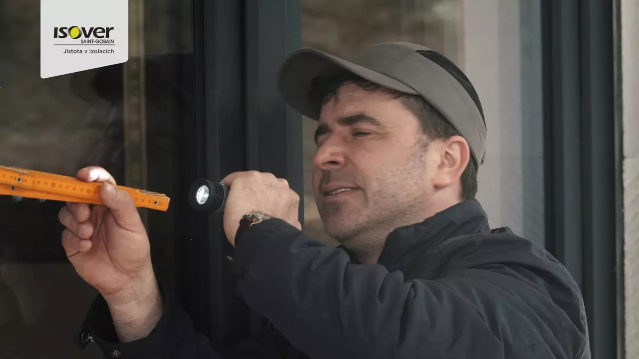Muž kontroluje kotvicí prvek pro styropor na fasádě.
