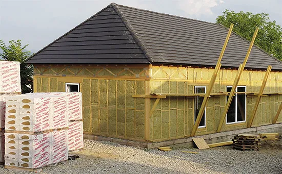 Dřevěný dům s izolačními materiály během zateplování.