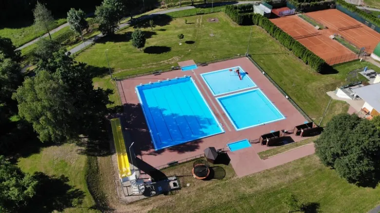 Vzdušný pohled na venkovní bazén s plaveckým bazénem a dětským bazénkem.