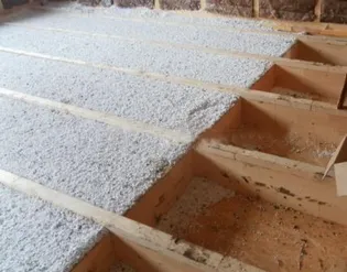 Sypaný a drcený EPS mezi trámy jako tepelná izolace podlahy.