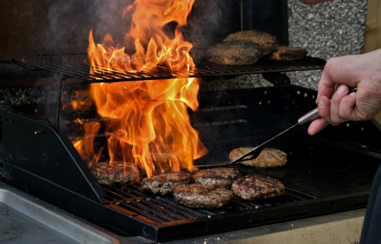 Grilování hamburgerů na zahradním krbu v pergole