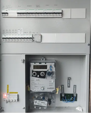 Otevřená elektrická rozvaděč s jističi a měřičem energie.
