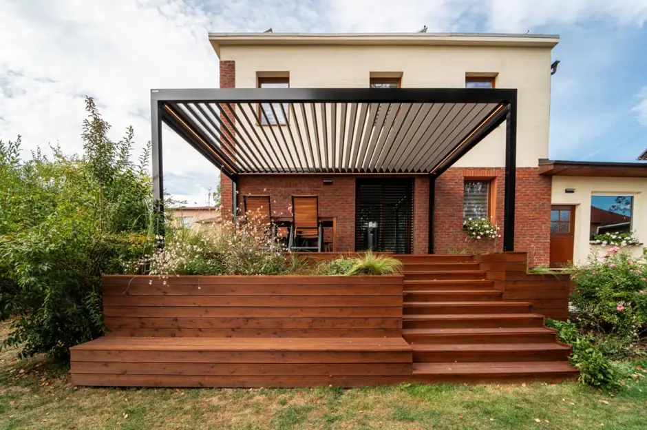 Bioklimatická pergola s dřevěnou terasou před domem