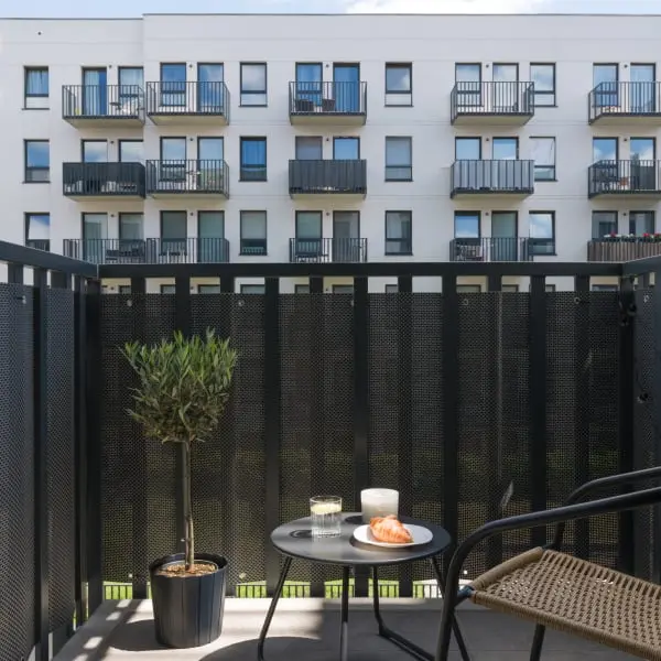 Modernizovaný balkon paneláku s podlahou, stolkem a židlí