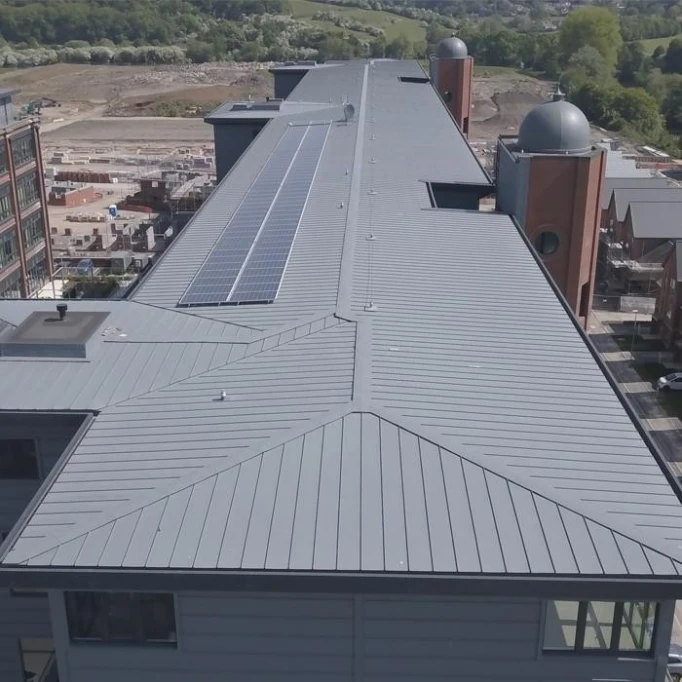 Falcovaný plech na střeše budovy s fotovoltaickými panely.