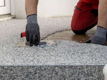 Montáž epoxidové stěrky na beton pomocí špachtle.
