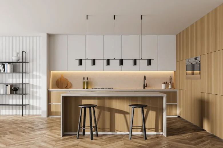 Moderní kuchyně s osvětlením pod skříněmi a visutými lampami.