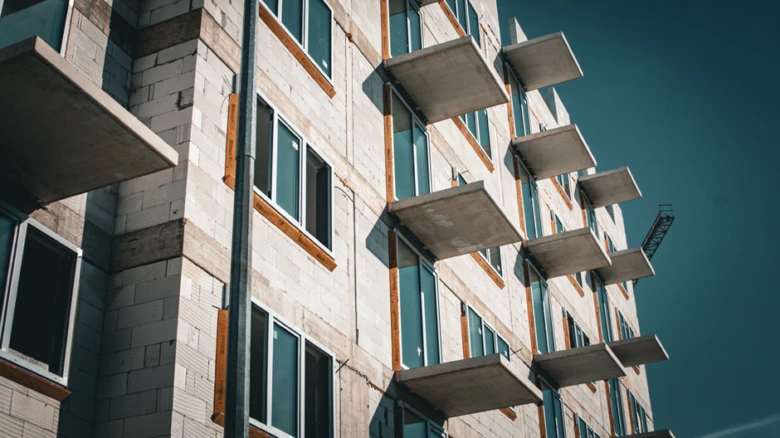 Modern budova s výčnělkovými balkony a montovanými okny.