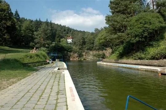 Přirozené koupaliště v lomu s okolní zeleňí.