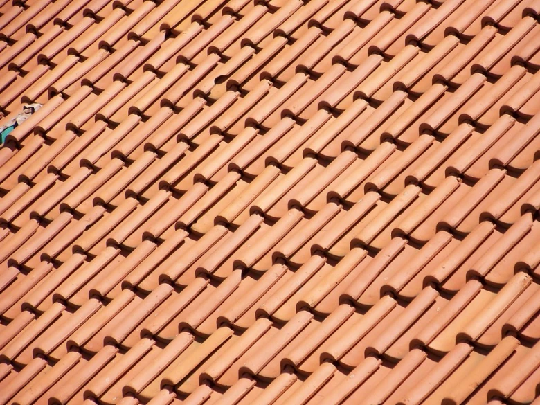 Detailní pohled na červené střešní tašky z keramiky.