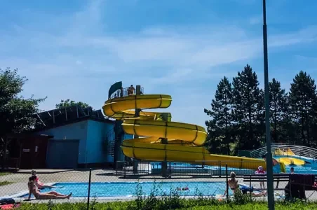 Žluté vodní skluzavky v bazénu s lidmi u Kyjova
