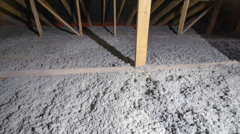Zateplení podlahy v půdě s izolačním materiálem mezi trámy.