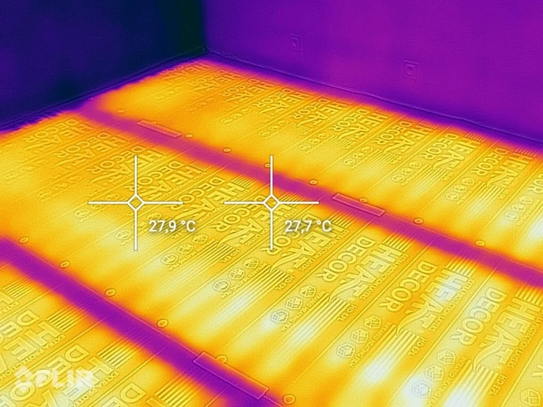 Termokamerový záběr topné folie s teplotami na podlaze.