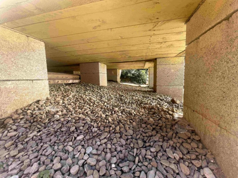 Konkrétní betonové patky pod dřevostavbou s kamenivem.