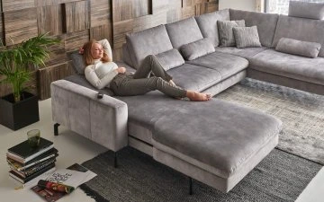 Šedá rozkládací sedací souprava s pohovkou pro relaxaci.