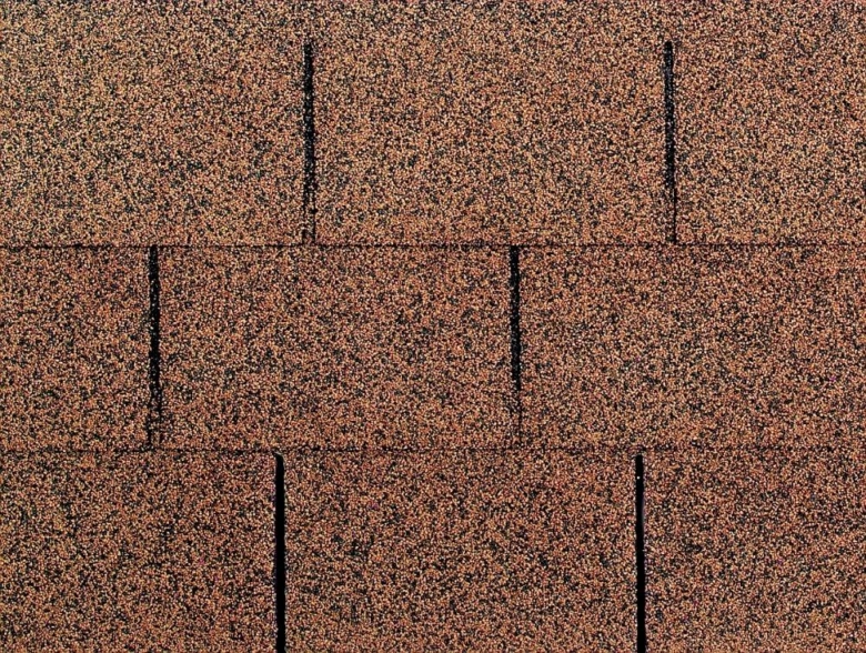 Detailní pohled na texturu asfaltových střešních šindelek.