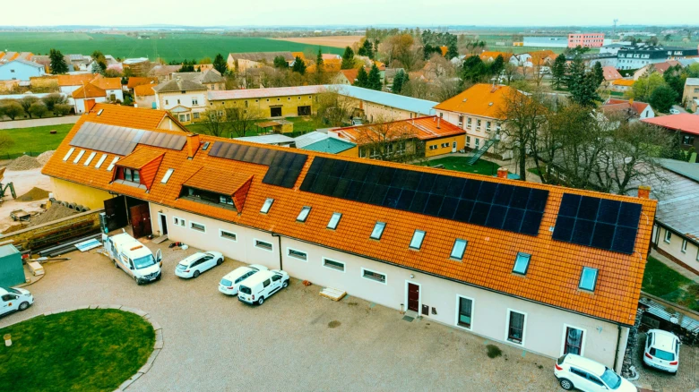 Fotografie montáže fotovoltaických panelů na střechu budovy s uzemněním.