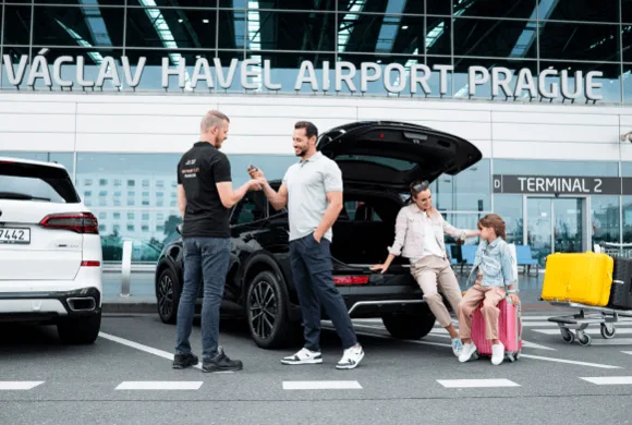 Lidé u auta před terminálem 2 v pražském letišti.
