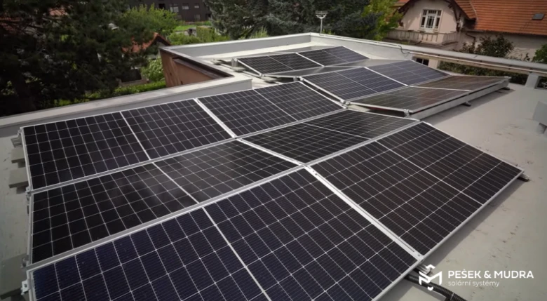 Fotografie fotovoltaických panelů na střeše budovy.