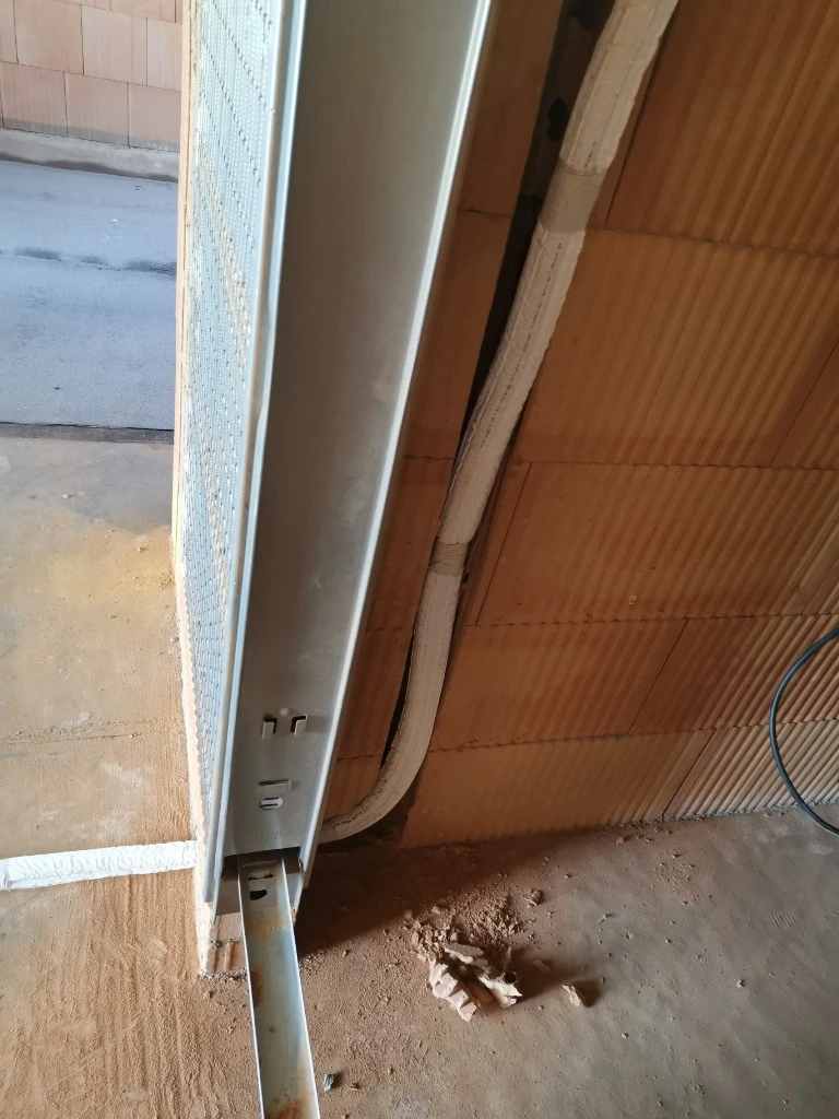 Instalace izolované klimatizační hadice v domě během rekonstrukce.