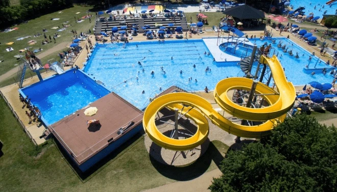 Vodní hřiště s bazény a žlutými vodními skluzavkami