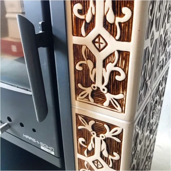 Detailní pohled na dekorativní keramické dlaždice u topného tělesa s výměníkem.