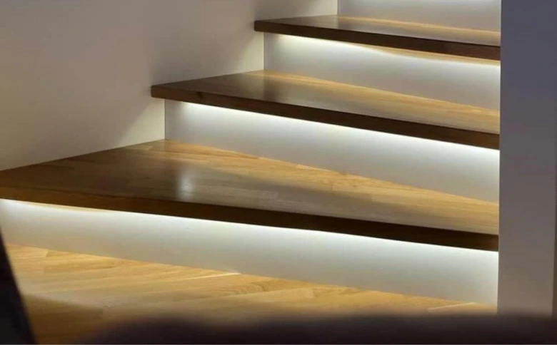 Moderní schodiště s dřevěnými stupni a podsvícením pomocí LED pásku.