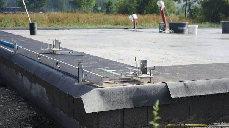Zalitá betonová podlaha s úrovněním během hrubé stavby rodinného domu.