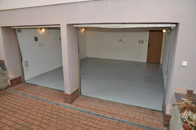 Dva otevřené garáže s novými nátěry podlah na betonu.