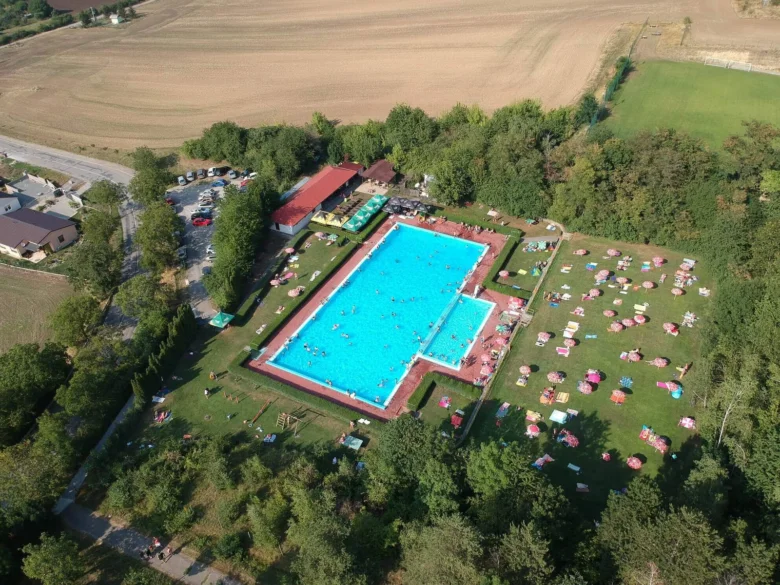 Vzdušný pohled na venkovní bazén v Bučovicích s lehátky.