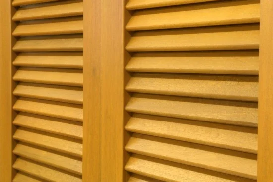 Detail dřevěných venkovních okenic s lamelami na okno.