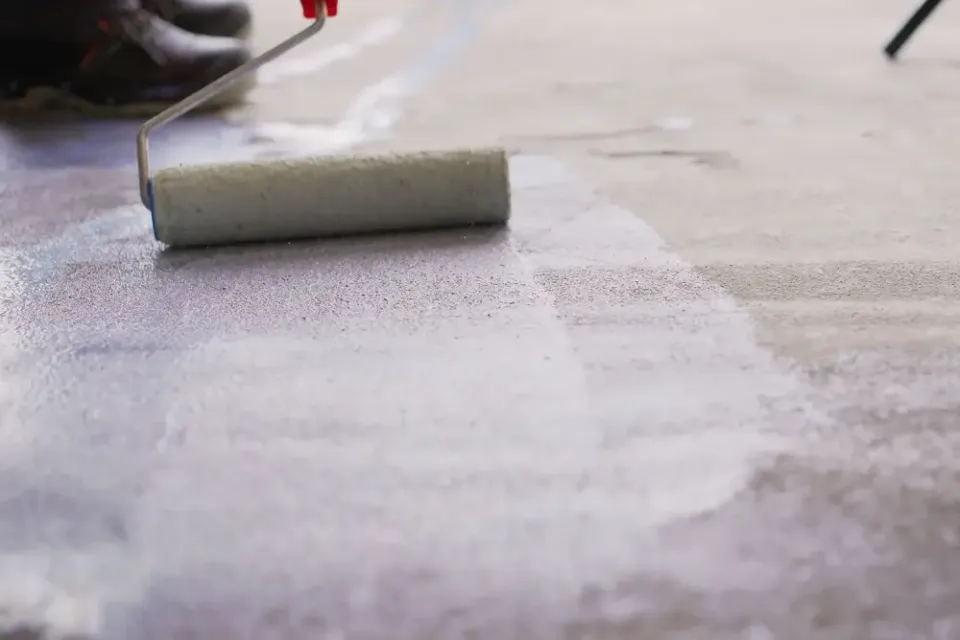 Nátěr betonu válcem při aplikaci penetrace.