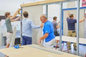 Muži montují kovový rámeček pro podhledy sádrokartonu.