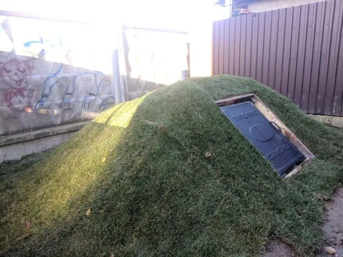 Zemní plastový sklep s trávníkem na povrchu pro skladování.