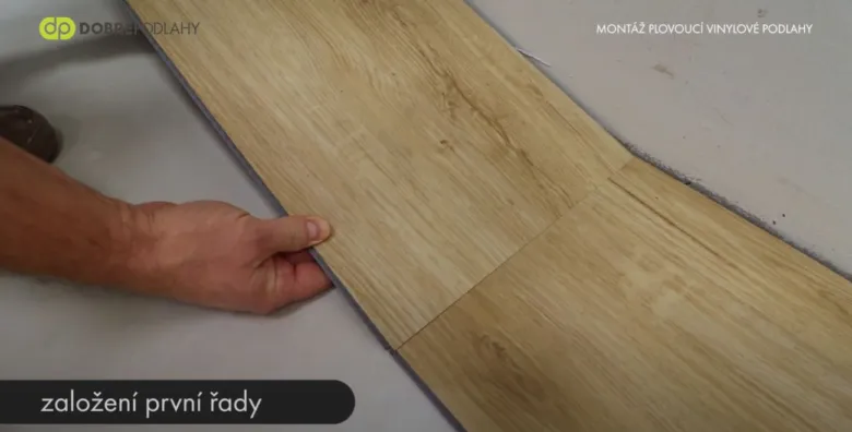 Ruční pokládka prvních řad vinylové podlahy.