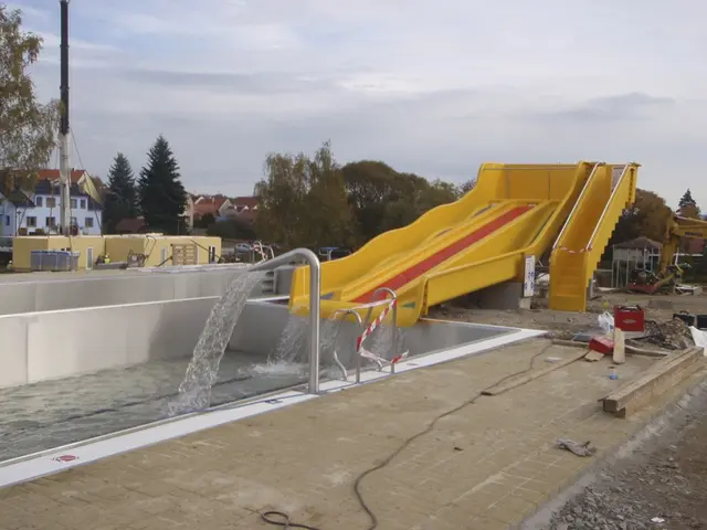 Stavba bazénu s žlutou vodní skluzavkou ve Velešíně.