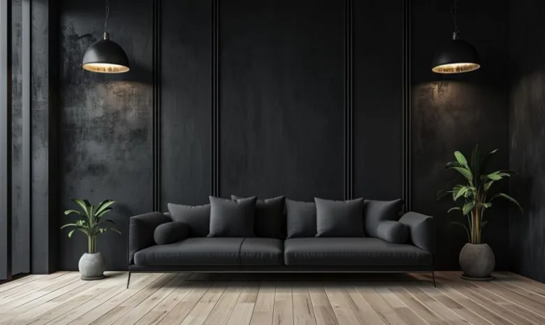 Moderní interiér s černým gaučem, tmavými stěnami a dřevěnou podlahou.