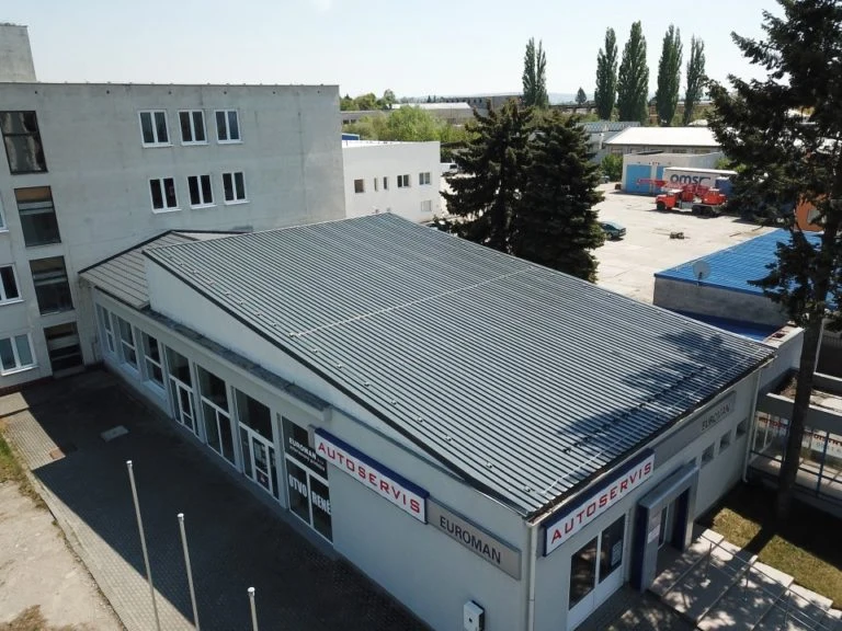 Pultová střecha s kovovými panely na budově autoservisu.