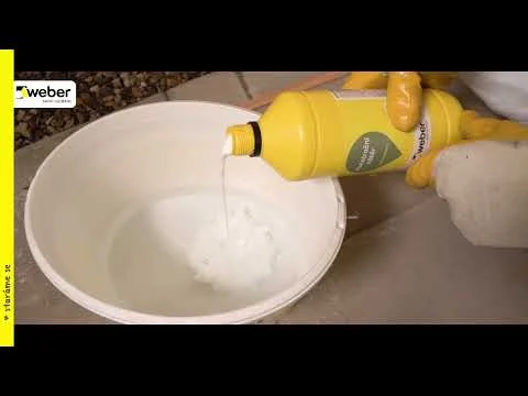 Člověk v žlutých rukavicích nalévá čisticí prostředek do kbelíku.