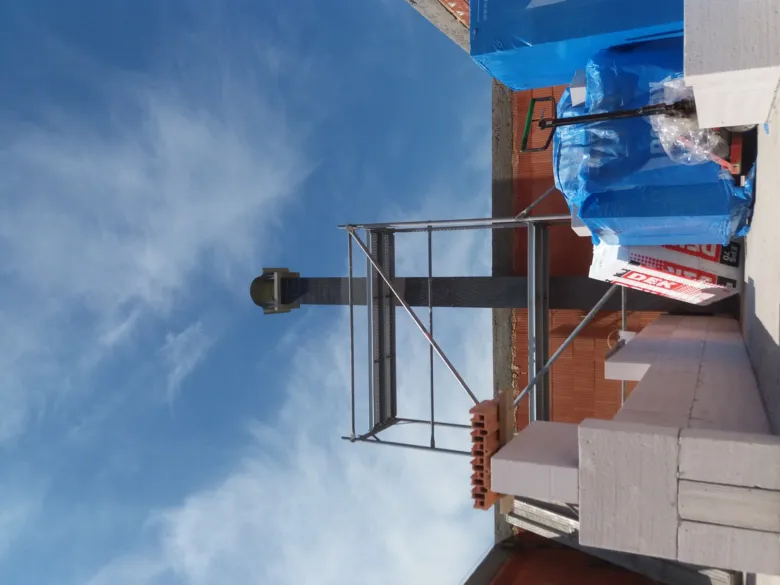 Stavba komínu s konstrukcí a materiály na staveništi.