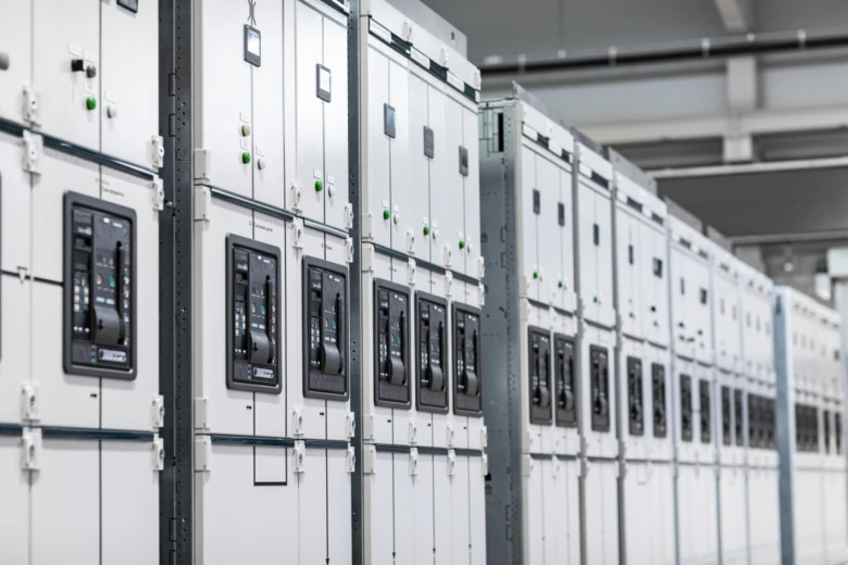Řada bílých elektrických rozvaděčů v průmyslovém prostředí.