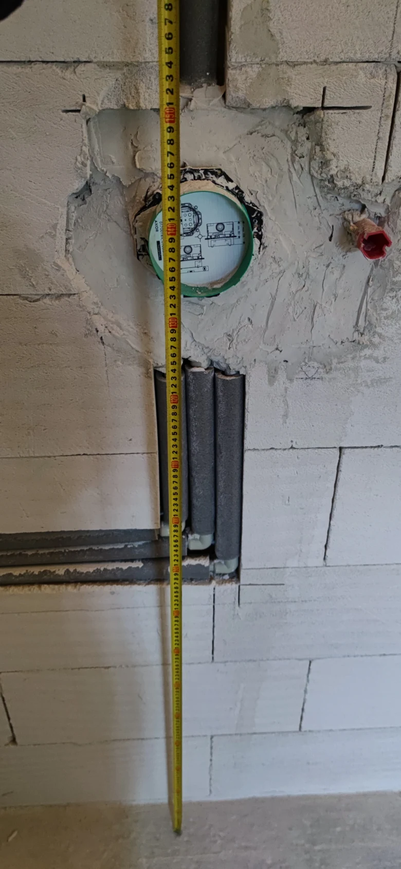 Plastové vodovodní trubky v zdivu během instalace.