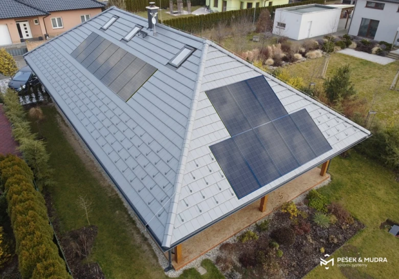 Fotovoltaické panely na střeše rodinného domu z výšky.
